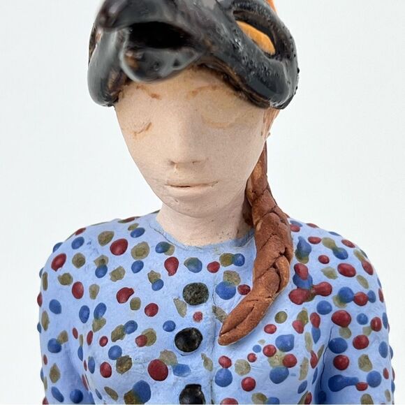 CARRIANNE L HENDRICKSON woman with beak hat sitting on apple sculpture 2… - Picture 4 of 16